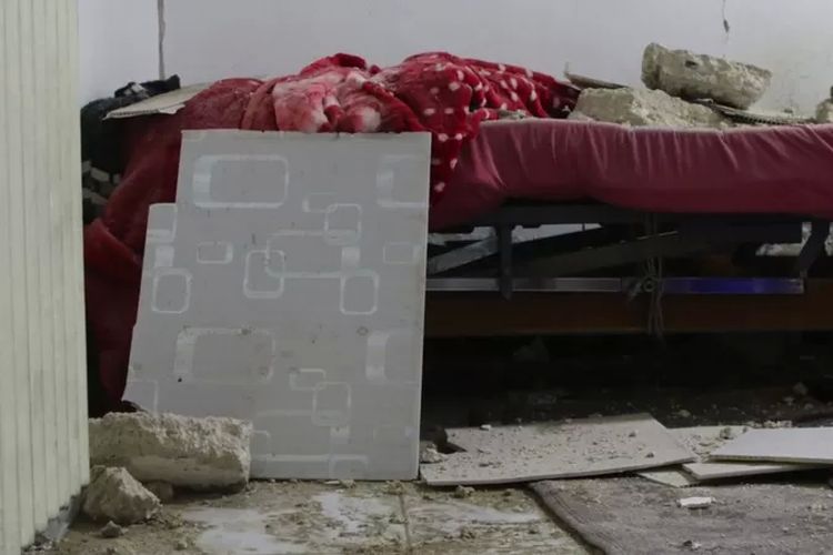 Reruntuhan bangunan menimpa tempat tidur di rumah sakit bersalin di al-Dana, Suriah.