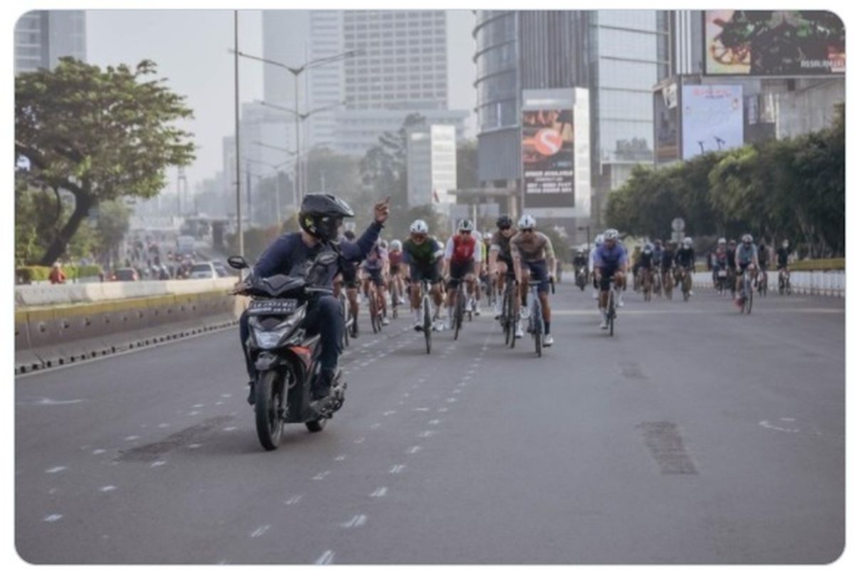 Tangkapan layar foto pengendara motor diduga pelat AA yang sedang mengacungkan jari tengah ke rombongan pesepeda.