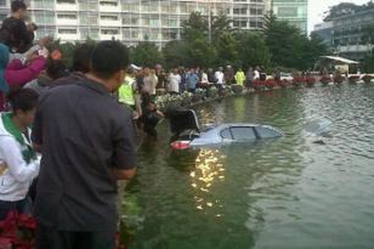 Sebuah sedan BMW nyemplung ke kolam Bundaran HI, Sabtu (24/8/2013) pagi sekitar pukul 05.00 WIB.