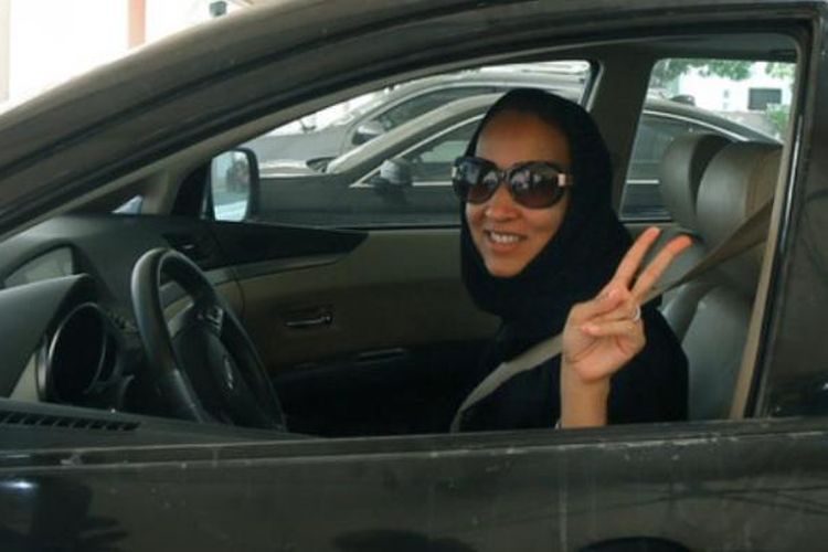 Aktivis perempuan Arab Saudi Manal al-Sharif, yang kini tinggal di Uni Emirat Arab, menunjukkan lambang kemenangan dengan jarinya saat dia mengemudikan mobilnya di Dubai.