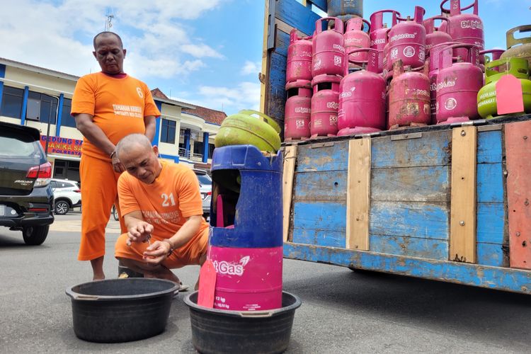 Tersangka memperagakam cara mengoplos gas elpiji 3 kg ke tabung gaa elpiji 12 kg di Mapolresta Cilacap. Jawa Tengah, Rabu (8/3/2023).