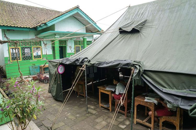 Sejumlah siswa kelas enam sekolah dasar, mengikuti Ujian Sekolah (US) di tenda darurat di halaman sekolah SD Negeri 1 Kasinoman, Kalibening, Banjarnegara, Jateng, Senin (23/4/2018). Sejumlah siswa sekolah dasar korban gempa bumi di Kecamatan Kalibening, Banjarnegara, terpaksa mengikuti ujian di tenda darurat karena gedung sekolah serta ruang kelas mereka sebagian ambruk dan rusak parah, sehingga tidak bisa digunakan.