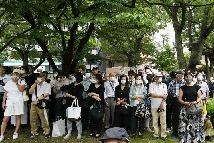 Para pengamat berkumpul di sebuah taman di seberang kuil Zojoji sebelum pemakaman mantan Perdana Menteri Jepang Shinzo Abe di Tokyo pada Selasa, 12 Juli 2022.
