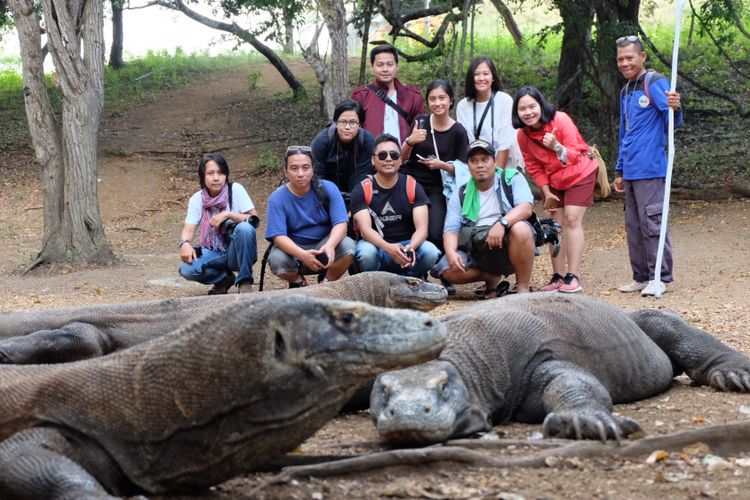 Wisatawan berfoto dengan komodo dan ranger Sulaiman di TN Komodo, Pulau Rinca, NTT.