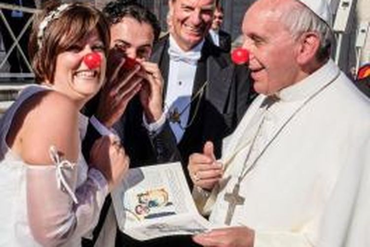 Paus Fransiskus mengenakan hidung badut berwarna merah untuk merayakan pernikahan dua anggota badan amal yang kerap menggunakan badut untuk menghibur anak-anak penderita kanker.