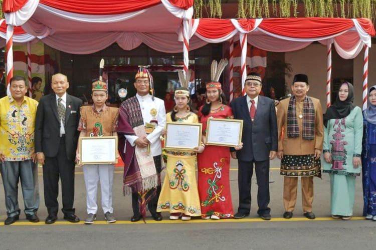 Mendikbud Muhadjir Effendy memberikan penghargaan kepada tiga siswa SMA Negeri 2 Palangka Raya, Kalimantan Tengah (17/8/2019) peraih medali emas juara dunia pada ajang Invention Creativity Olympic, di Seoul, Korea Selatan atas karya ilmiah menemukan obat penyembuh kanker dari tanaman bajakah. 