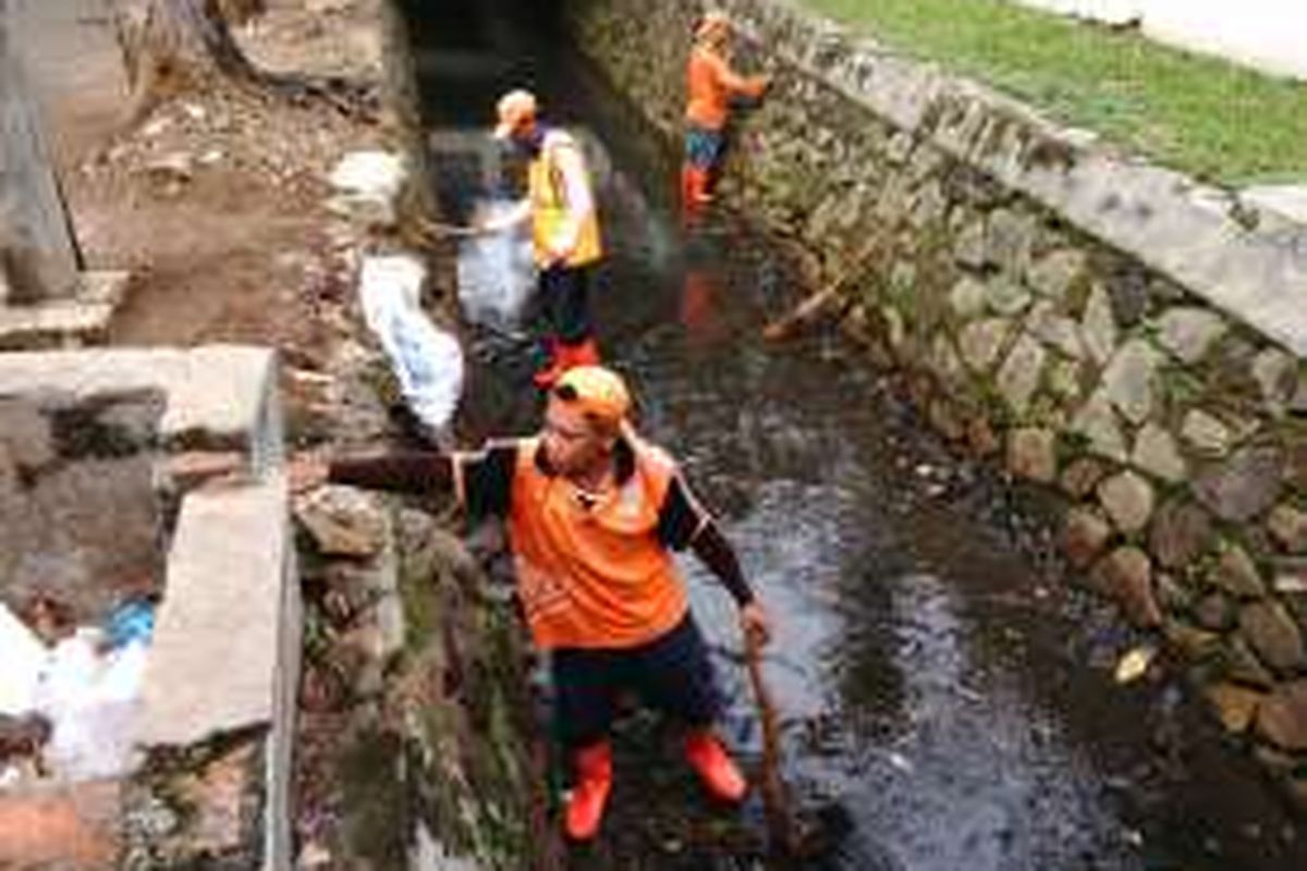 Sejumlah petugas prasarana dan sarana umum (PPSU) nampak sedang bekerja membersihkan sampah di Kali Penghubung daerah aliran sungai Mampang di kawasan Kelurahan Bangka, Kecamatan Pancoran, Jakarta Selatan. Senin (16/5/2016).  