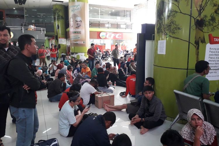 Sekira 100 calon pemudik terpaksa duduk lesehan di Aula Kedatangan Stasiun Gambir karena minimnya junlah bangku, Sabtu (9/6/2018).