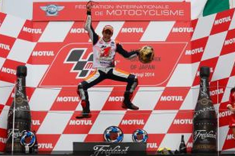 Pebalap Repsol Honda asal Spanyol, Marc Marquez, melompat di atas podium untuk merayakan kepastian menjadi juara dunia setelah finis kedua pada GP Jepang di Sirkuit Twin Ring Motegi, Minggu (12/10/2014).