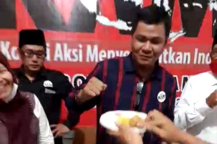 Presidium KAMI Jambi Amrizal Ali Munir memotong tumpeng setelah bernegosiasi dengan pihak kepolisian yang membubarkan acara deklarasi, Jumat (30/10/2020).