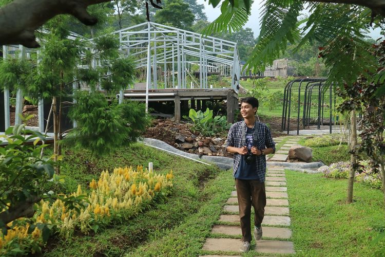 Pengunjung berjalan melewati taman bunga Leuweung Geledegan Ecolodge Bogor, Minggu (8/12/2019).