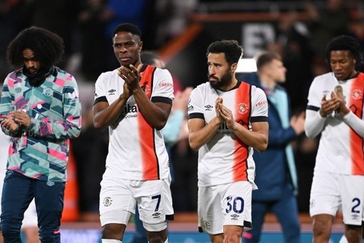 Dua pemain Luton Town, Chiedozie Ogbene (kiri) dan Andros Townsend, bertepuk tangan sebagai bentuk dukungan kepada kapten tim, Tom Lockyer, yang kolaps dalam laga melawan Bournemouth pada lanjutan Liga Inggris 2023-2024 di Vitality Stadium, Sabtu (16/12/2023) WIB.