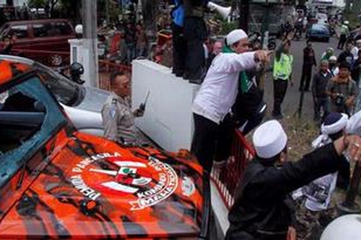 Massa yang mengenakan atribut Laskar Pembela Islam terlibat bentrok dengan salah satu anggota ormas usai digelarnya sidang vonis kasus penyebaran video Nazriel Irham alias Ariel Peterpan, di samping Pengadilan Negeri Bandung, Jawa Barat, Senin (31/1/2011). Akibat bentrokan ini, sebuah mobil mengalami kerusakan pada bagian kaca depannya. 