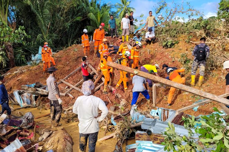 This handout picture taken on March 8, 2023 and released on March 9, 2023 by ministry of communication and information shows rescue team evacuate the body of a victim that was found buried by a landslide at Pangkalan village, in Natuna Islands. (Photo by Handout / Natuna Ministry of Communication / AFP) 