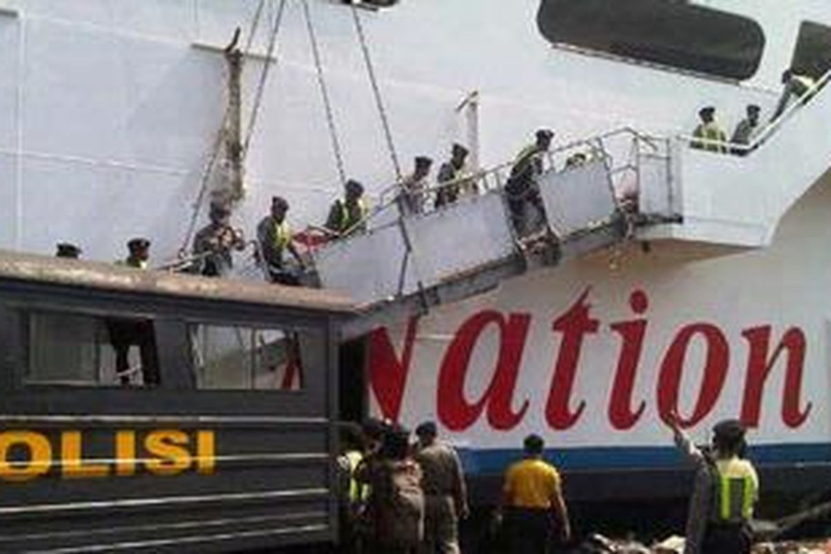 Polisi menurunkan barang dari KM Kirana yang terbakar di dermaga Gapura Surya Pelabuhan Tanjung Perak, Surabaya, Jawa Timur, Rabu (28/9/2011).