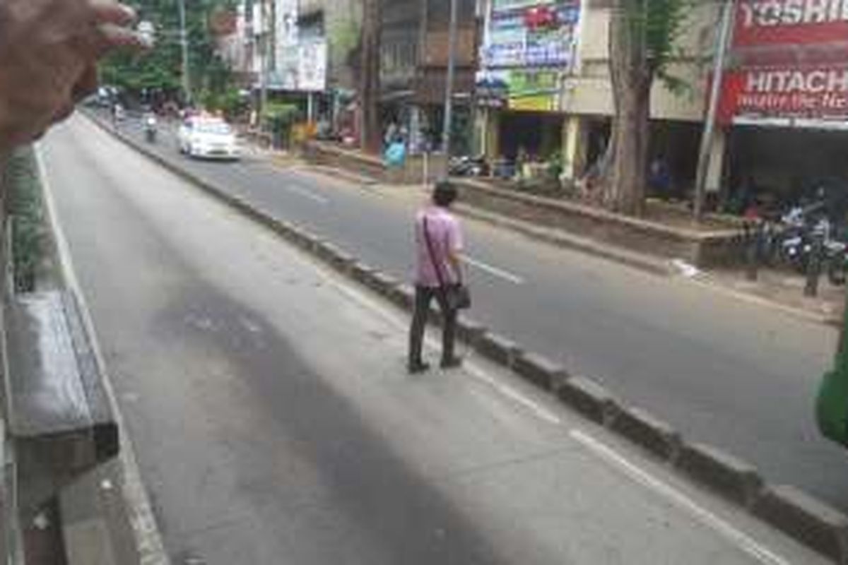 Salah seorang penumpang transjakarta yang baru saja melompat dari Halte Jatinegara, Senin (22/2/2016). Selama hampir 30 menit, bus transjakarta rute Kampung Melayu-Pulogebang tak kunjung tiba di Halte Jatinegara. Akibatnya, sebagian penumpang memilih keluar halte untuk mencari moda angkutan yang lain.