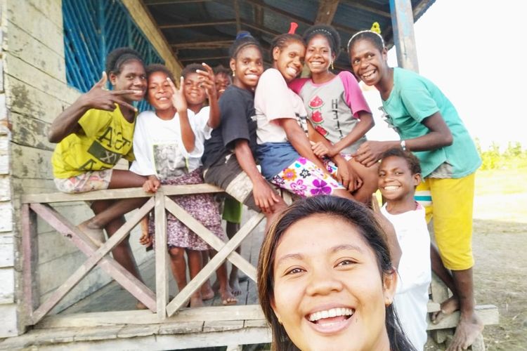 Diana Cristian Da Costa Ati (23 tahun) berfoto bersama dengan para siswanya di SD Inpres Kaibusene, Distrik Haju, Kabupaten Mappi, Papua