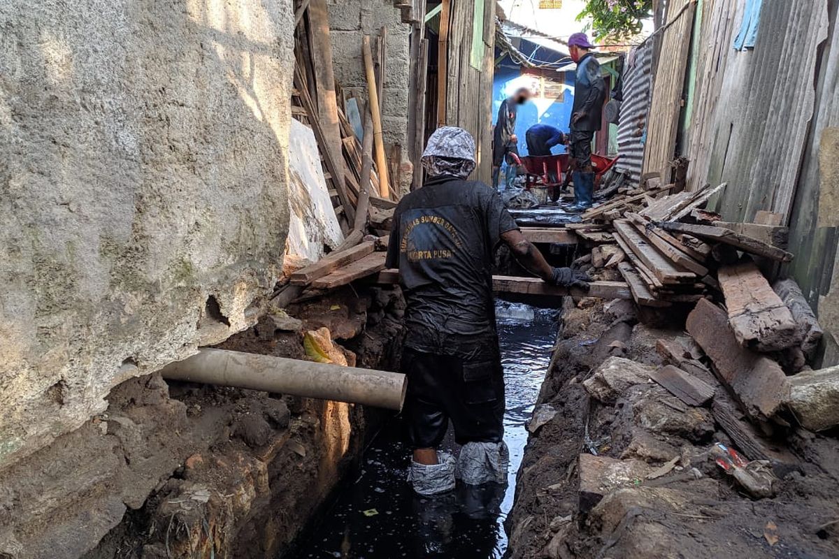 Petugas Satuan Pelaksana Tugas SDA Kemayoran melakukan pengurasan saluran air di RW 8 Kebon Kosong, Kemayoran, Jakarta Pusat, Jumat (4/6/2021) 