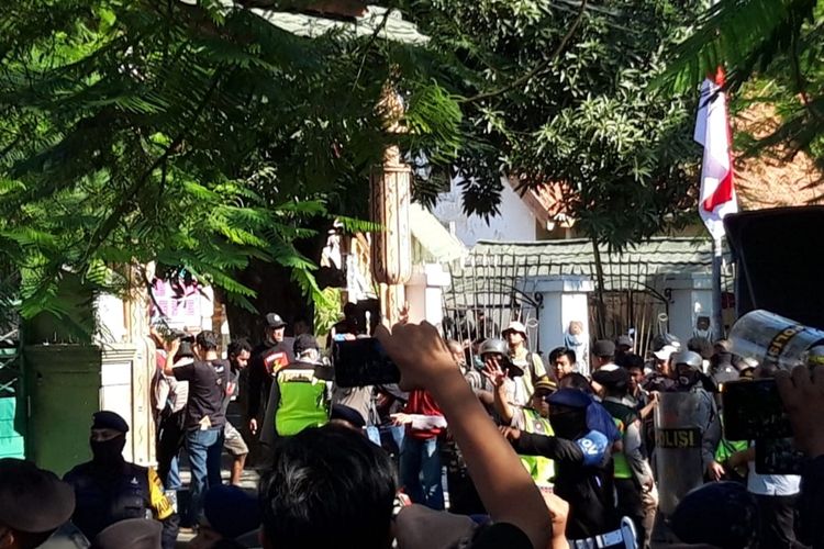 Sejumlah polisi menggunakan perisai mendobrak dan menjebol pintu pagar Asrama Papua Surabaya di Jalan Kalasan, Surabaya, Jawa Timur, Sabtu (17/8/2019).