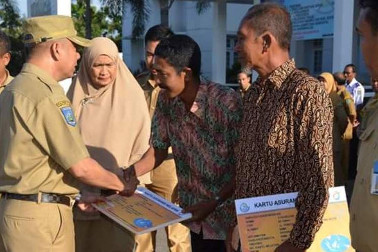 Wakil Wali Kota Bima A Rahman membagikan kartu asuransi secara simbolis kepada nelayan di halaman kantor Wali Kota Bima, Senin (27/2/2017). 