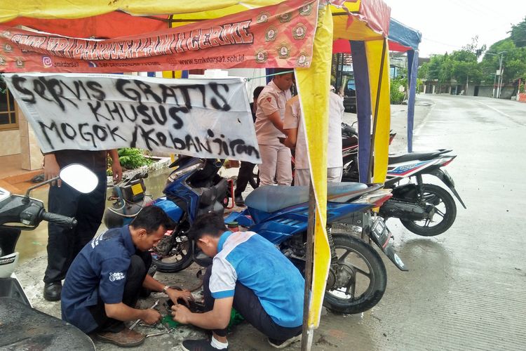 Para siswa rela membantu pengendara yang motornya mogok di Jalan Raya Morowudi secara gratis, Rabu (8/1/2020).