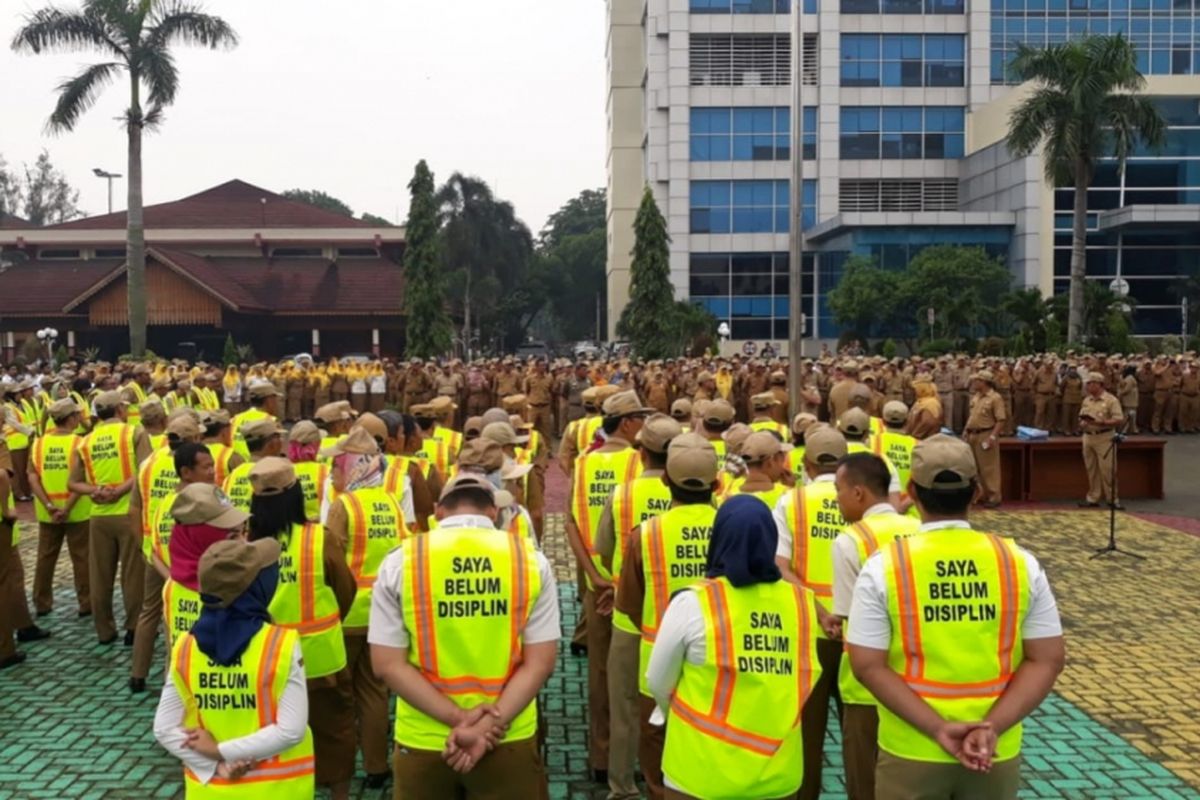 Tak disiplin, ratusan PNS (Pegawai Negeri Sipil) dan TKK (Tenaga Kerja Kontrak) Pemkot Bekasi dihukum jera kenakan rompi bertuliskan Saya Belum Disiplin saat apel pagi di Lapangan Kantor Pemkot Bekasi, Senin (14/1/2019).