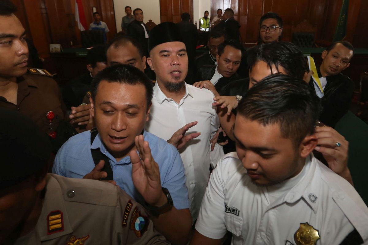 Terdakwa kasus pencemaran nama baik Ahmad Dhani (tengah) didampingi petugas meninggalkan ruang sidang usai menjalani sidang lanjutan di Pengadilan Negeri (PN) Surabaya, Jawa Timur, Selasa (12/2/2019). Sidang kedua tersebut beragendakan pembacaan eksepsi atau nota keberatan atas dakwaan jaksa penuntut umum dalam kasus dugaan pencemaran nama baik.