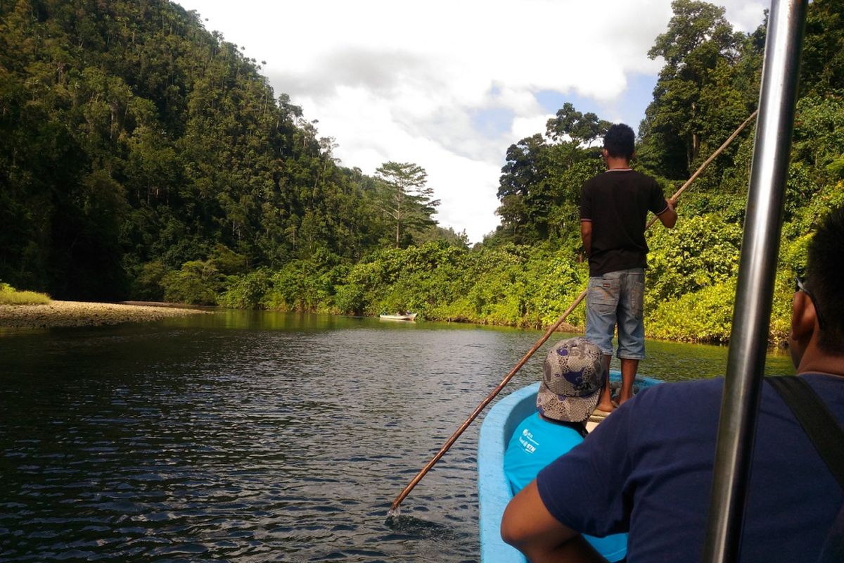 Mundi Daman, siswa kelas XI di sebuah SMA di Waisai, Raja Ampat, mendampingi wisatawan yang berkunjung ke Kali Biru di distrik Teluk Mayalimbit, Kabupaten Raja Ampat, Jumat (4/5/2018).