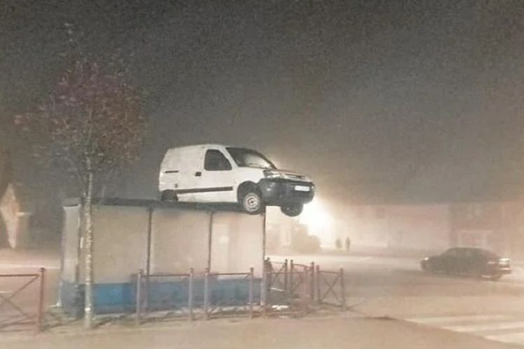 Foto yang diunggah gendarmerie di Plouneventer, Perancis, memperlihatkan sebuah mobil van putih terdampar di atap halte bus.