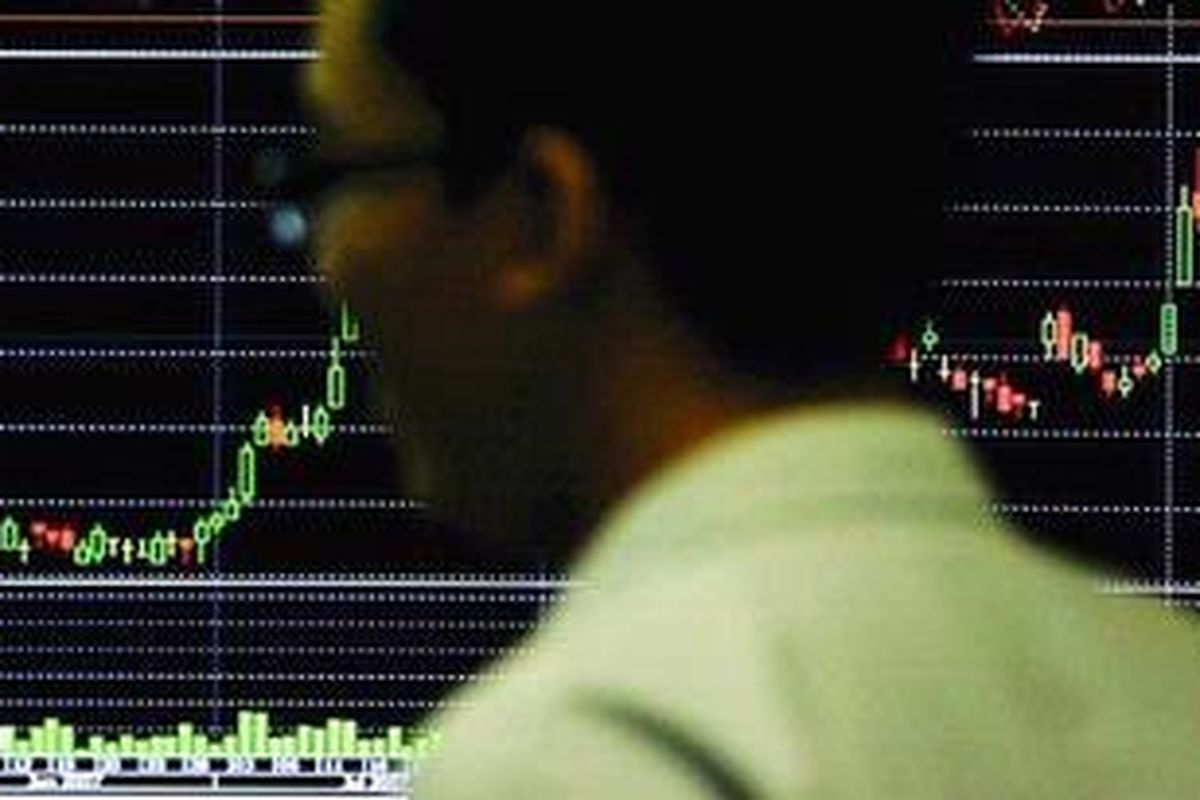 Investor melintas di depan monitor pergerakan saham di Bursa Efek Indonesia.