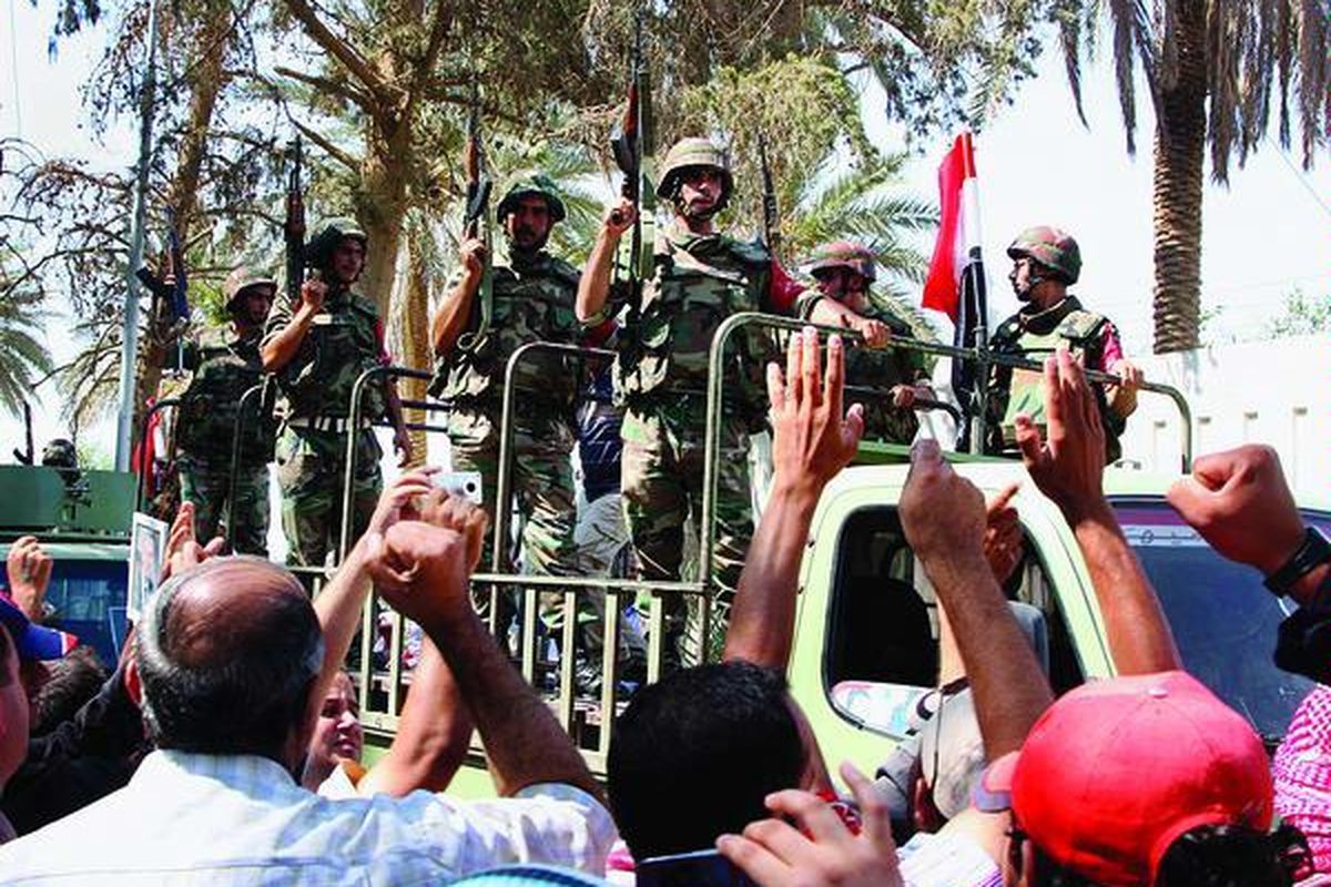 Penduduk Suriah  mengelu-elukan  pasukan Suriah yang meninggalkan kota Deir el-Zour, Selasa (16/8), dalam gambar yang diambil oleh pewarta foto yang diorganisasikan Pemerintah Suriah. Kantor berita SANA mengatakan, tentara mulai ditarik dari Deir el-Zour setelah melakukan operasi memberantas 