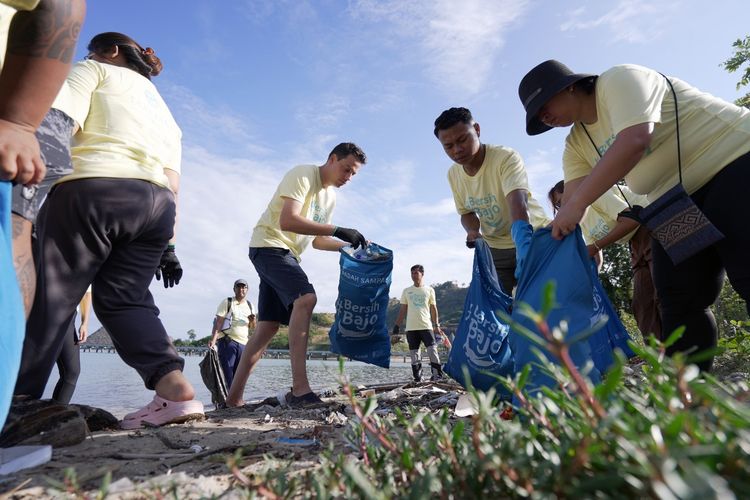 Para peserta Bersih Bajo Chapter 4 memungut sampah di pesisir Pantai Wae Rana.