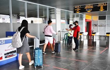 Petugas memantau penerapan Social Distancing pada antrian penumpang yang hendak memasuki gate keberangkatan di salah satu terminal penumpang yang dikelola Pelindo 1, Rabu (23/12/2020)