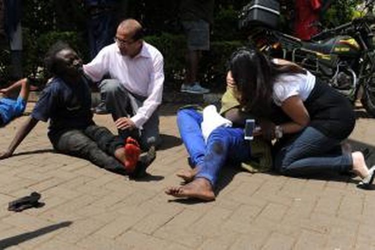 Dua orang korban luka dalam tragedi penembakan di pusat perbelanjaan di Nairobi, Kenya dibantu para pejalan kaki setelah berhasil diselamatkan dari dalam mal mewah tersebut.