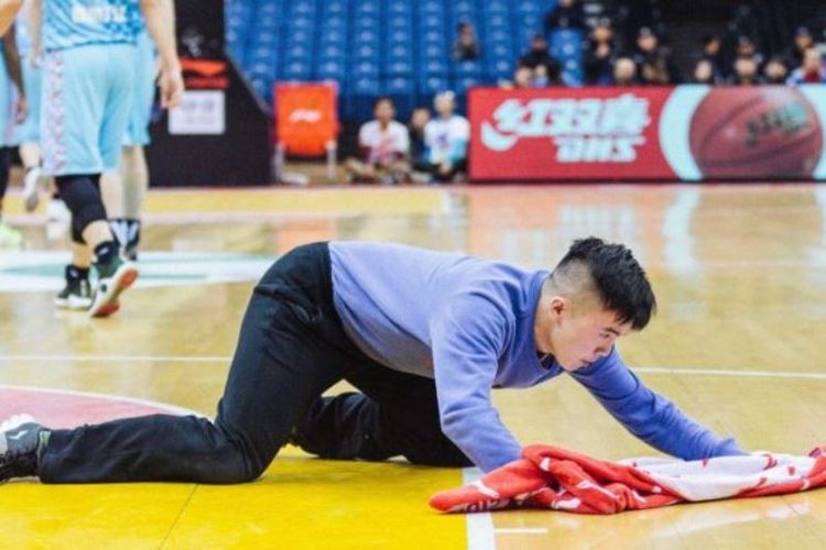 Meng Fei ketika membersihkan lantai dalam sebuah pertandingan basket.
