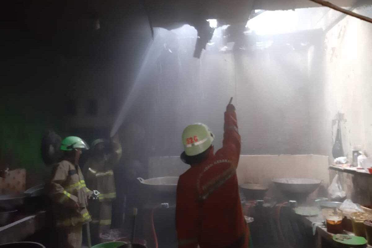 Sejumlah petugas Suku Dinas Penanggulangan Kebakaran dan Penyelamatan (Sudin PKP) Jakarta Timur tengah memadamkan api yang membakar rumah makan di Jalan Haji Hasan, Pasar Rebo, Jakarta Timur, Jumat (13/12/2019).