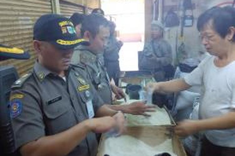 Petugas Polisi Pamong Praja melakukan pengecekan beras saat sidak di Pasar Kebayoran Lama pada Selasa (26/5/2015) siang.