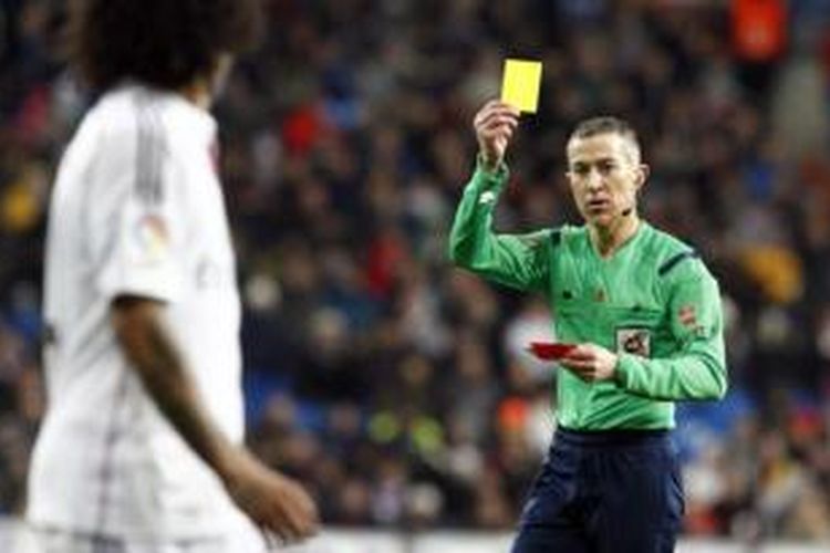  Wasit Ignacio Iglesias Vilanueva memberikan kartu kuning kepada bek Real Madrid, Marcelo, pada pertandingan lanjutan Primera Division, melawan Sevilla, di Santiago Bernabeu, Rabu (4/2/2015). 