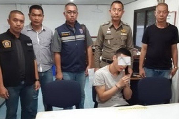 Pria China bernama Yu Xiaodong ketika berada di kantor polisi Thailand. Dia dituduh telah mendorong istrinya yang tengah hamil dari tebing.