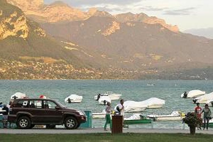 Danau Annecy, Perancis, pada sore hari dipenuhi aktivitas berjalan-jalan atau menuntun hewan peliharaan dengan pemandangan matahari tenggelam. Danau ini disebut sebagai danau terbersih di Eropa. 