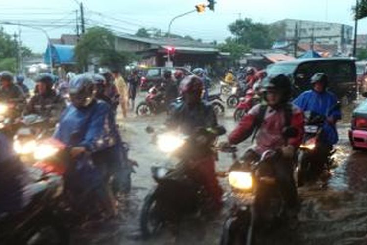 Para pengendara sepeda motor nekat menerobos genangan air di pertigaan Hek, Kramatjati, Jakarta Timur, Senin (24/11/2014).
