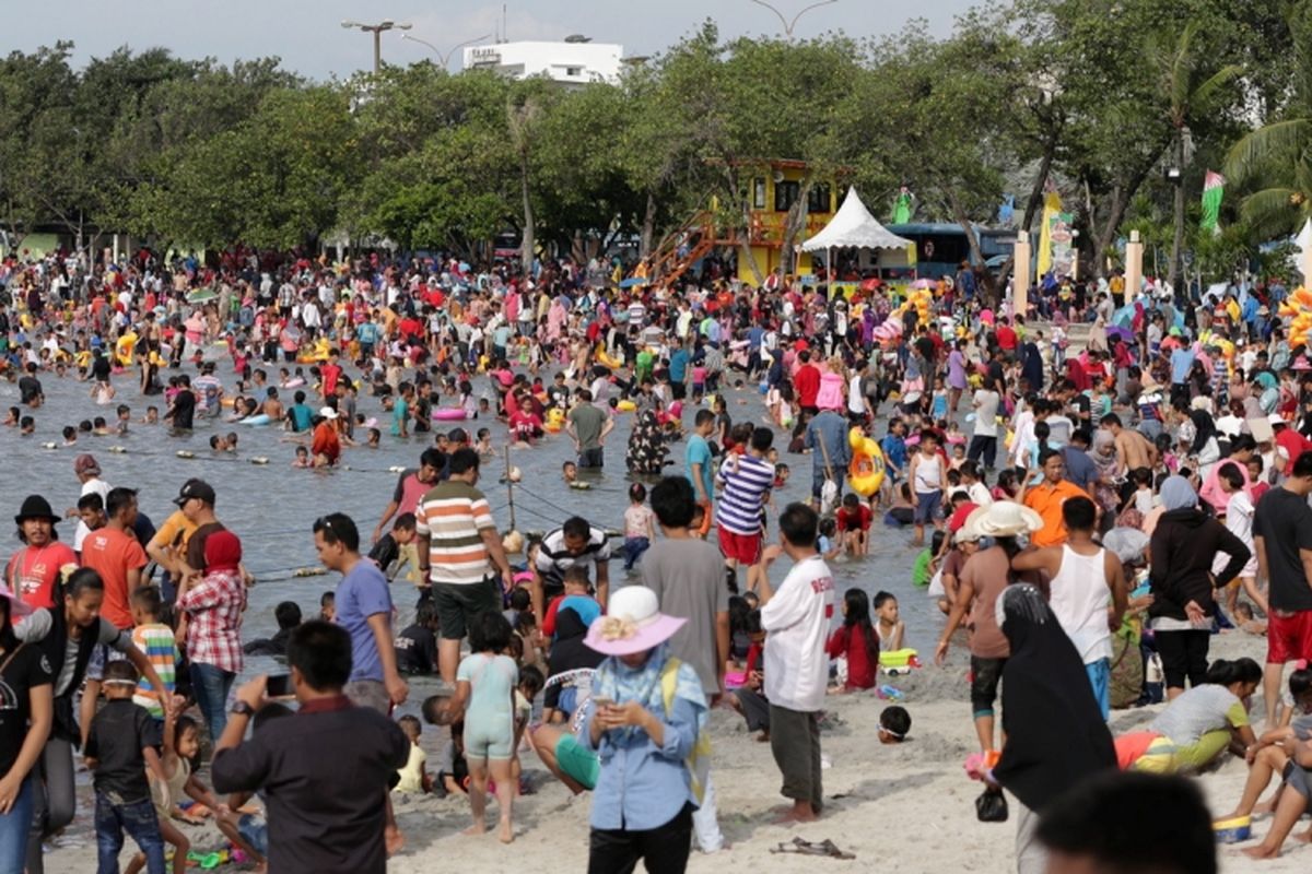 Pengunjung memanfaatkan liburan mengunjungi pantai di kawasan Taman Impian Jaya Ancol, Jakarta, Selasa (27/6/2017). Sejumlah lokasi wisata di Jakarta padat pengunjung pada libur lebaran. 