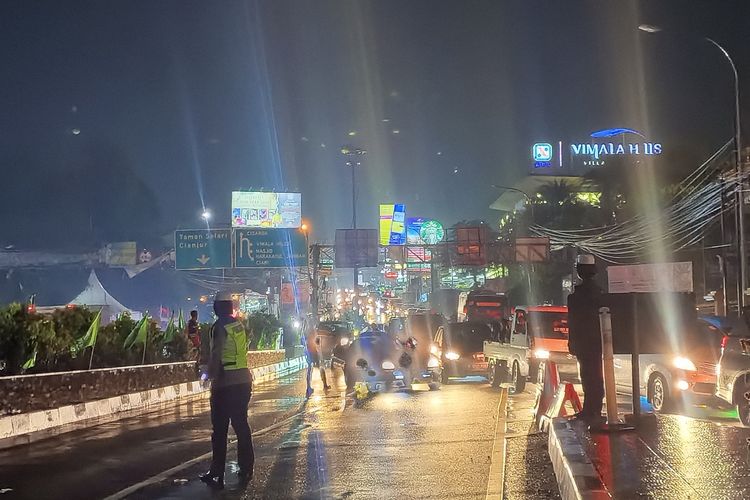 Polisi menghentikan rekayasa lalu lintas one way di Jalur Wisata Puncak Bogor, Jawa Barat, Selasa (26/12/2023).
