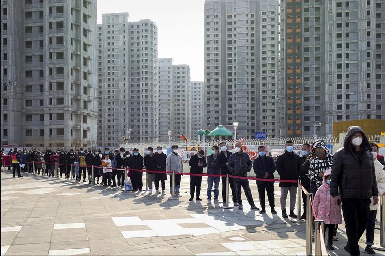 Warga dengan mengenakan masker mengantre tes Covid-19 di kota Tianjin, China utara, Minggu (9/1/2022). Tianjin menguji 14 juta warganya setelah muncul belasan kasus Covid-19 yang dua di antaranya adalah varian Omicron.