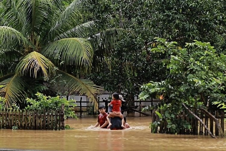 Seorsng warga di Seluma, Bengkulu mengevakuasi seorang anak kecil. Hujan sepanjang dua hari terakhir akibatkan sejumlah daerah di Bengkulu terkena banjir. Ratusan rumah terendam, jalan longsor melanda Bengkulu