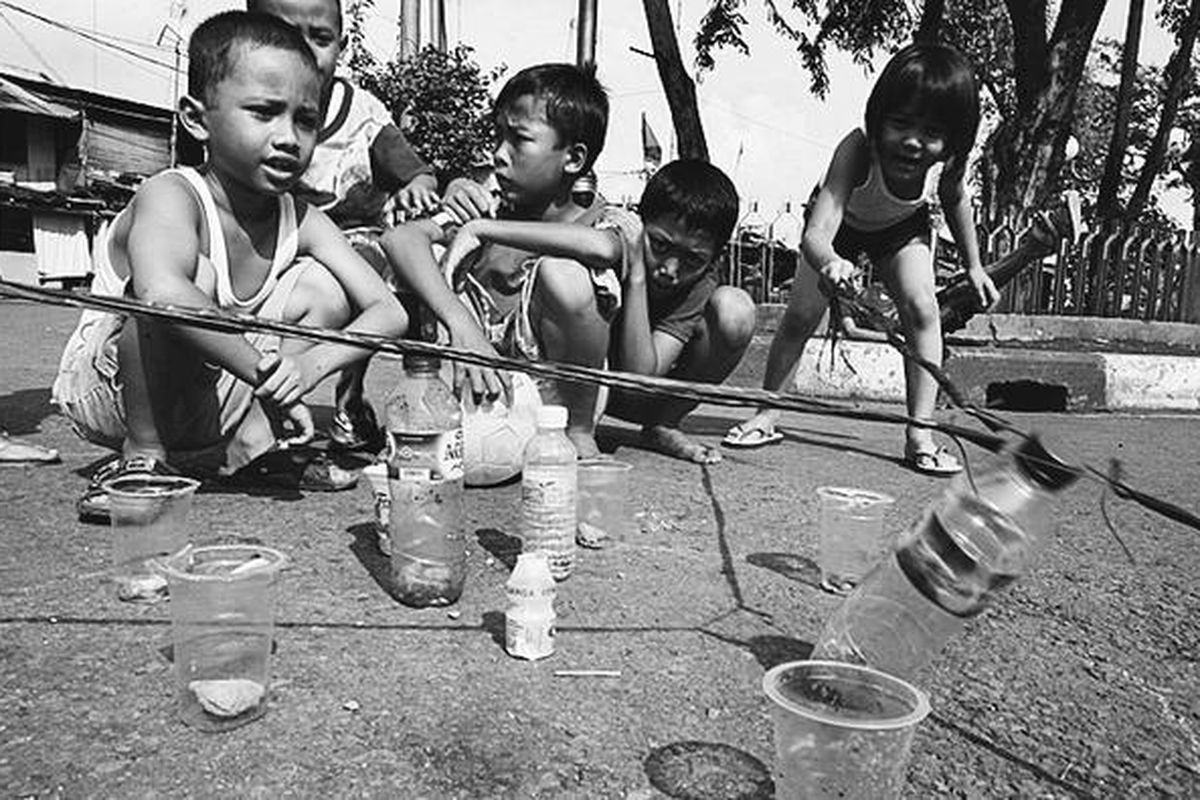 Anak-anak di kawasan perkampungan padat di daerah Manggarai, Jakarta, menciptakan sendiri permainan pancingan dengan menggunakan botol dan gelas bekas berisi batu kerikil yang diandaikan sebagai uang, Selasa (11/11). Anak-anak memiliki kreativitas sendiri untuk menciptakan permainan menggunakan barang-barang di sekitarnya.  
