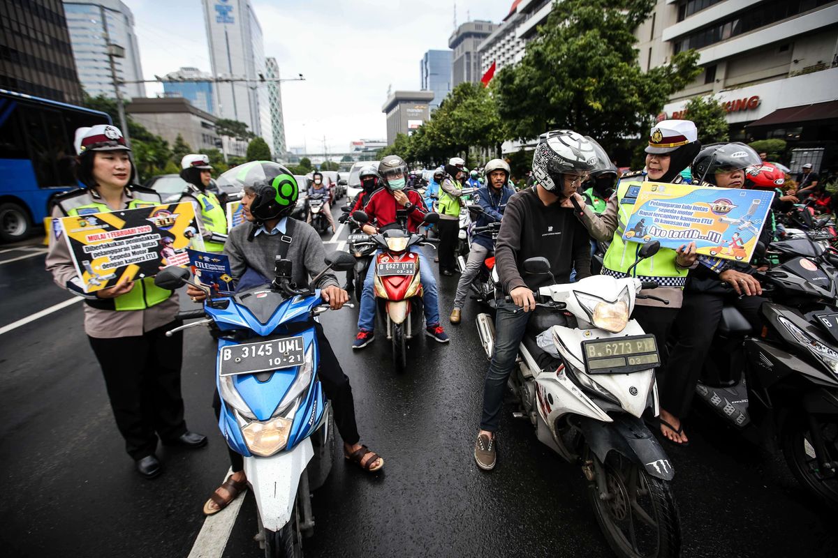 Petugas kepolisian dari direktorat lalu lintas (Ditlantas) Polda Metro Jaya menyosialisasikan penerapan sistem tilang elektronik atau electronic traffic law enforcement (ETLE) untuk kendaraan roda dua atau motor di Simpang Sarinah, Thamrin, Jakarta Pusat, Senin (3/2/2020). Untuk saat ini sistem ETLE untuk pengendara sepeda motor fokus pada penindakan tiga pelanggaran, yakni penggunaan helm, menerobos traffic light, dan melanggar marka jalan. Penerapan aturan tersebut telah resmi diberlakukan mulai Sabtu (1/2/2020).