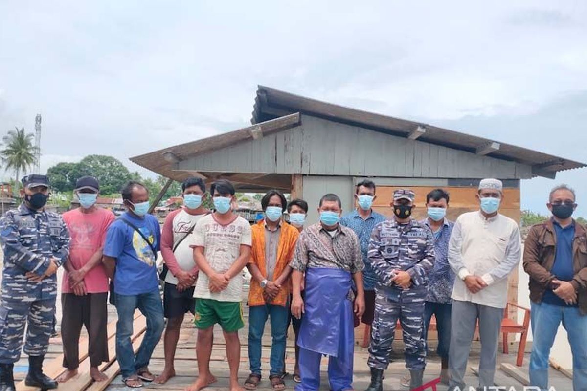 Danposal Idi Rayeuk Letda Laut (E) Mustamin bersama sembilan nelayan yang diselamatkan di Posal Idi Rayeuk, Senin (28/2/2022).
