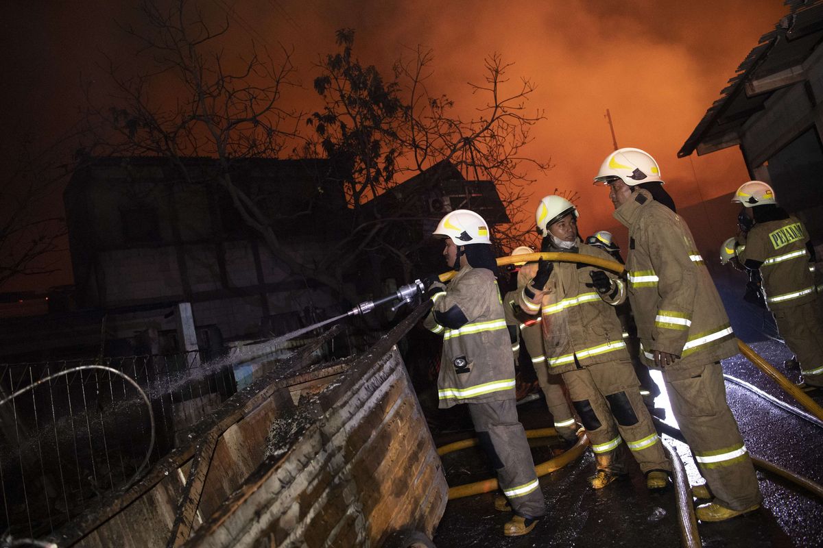 Sejumlah petugas berusaha memadamkan api yang membakar rumah warga imbas kebakaran Depo Pertamina Plumpang,kawasan Jalan Koramil, Rawa Badak Selatan, Koja, Jakarta Utara, Jumat (3/3/2023).
