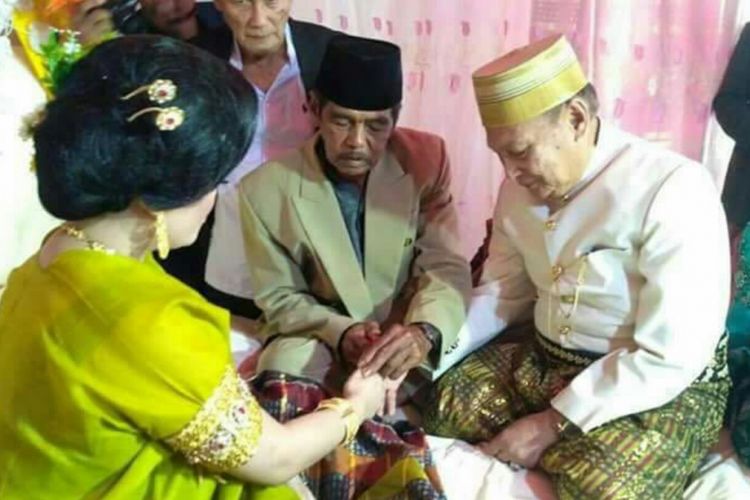 Mempelai pria tengah memasangkan cincin kawin ditengahi penghulu usai ijab kabul digelar antara kekak 70 tahun dengan gadis 25 tahun di Kabupaten Bone, Sulawesi Selatan. Sabtu, (22/4/2017).